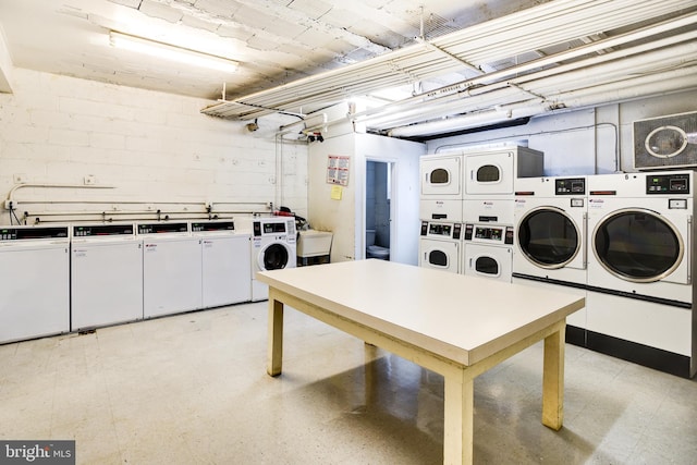 common laundry area with a sink, light floors, washing machine and dryer, and stacked washer / drying machine