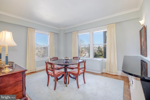 dining room featuring baseboards, plenty of natural light, and crown molding