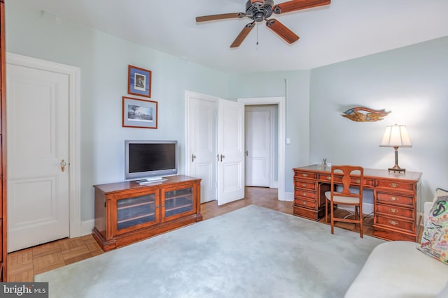 office space with a ceiling fan and baseboards