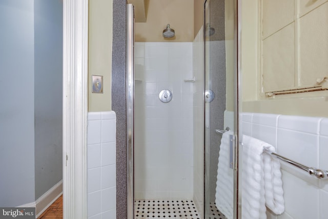 full bathroom featuring a stall shower and tile walls