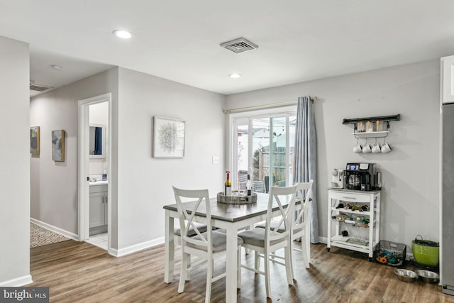 dining space with recessed lighting, wood finished floors, visible vents, and baseboards