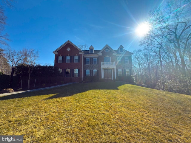 view of front of house featuring a balcony and a front lawn