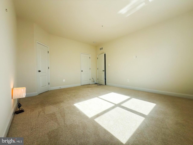 unfurnished bedroom with visible vents, light colored carpet, and baseboards