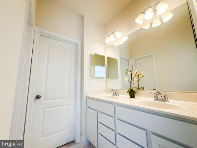 full bathroom with a sink and double vanity