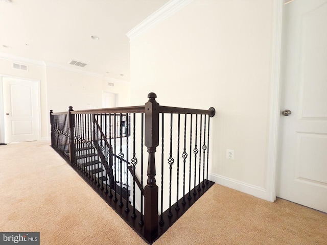 corridor featuring visible vents, ornamental molding, and carpet floors