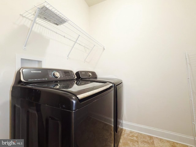 laundry room featuring washer and dryer, laundry area, light tile patterned floors, and baseboards