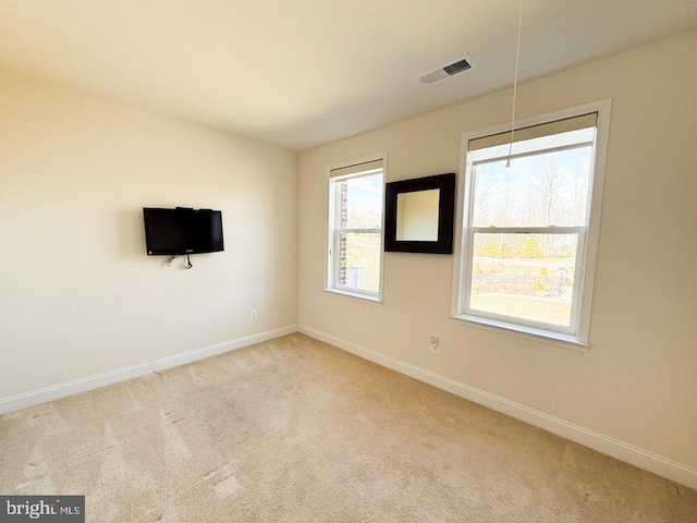 empty room featuring carpet flooring, baseboards, and visible vents