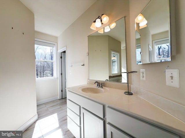 bathroom with vanity, baseboards, and tile patterned flooring