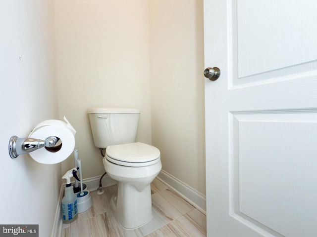 bathroom with baseboards and toilet