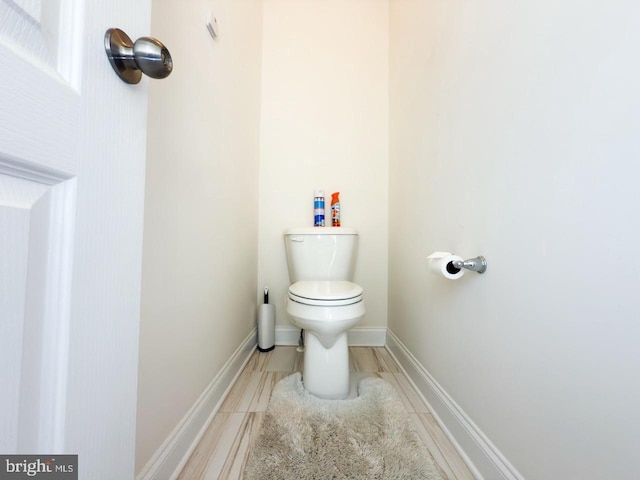 bathroom featuring toilet and baseboards