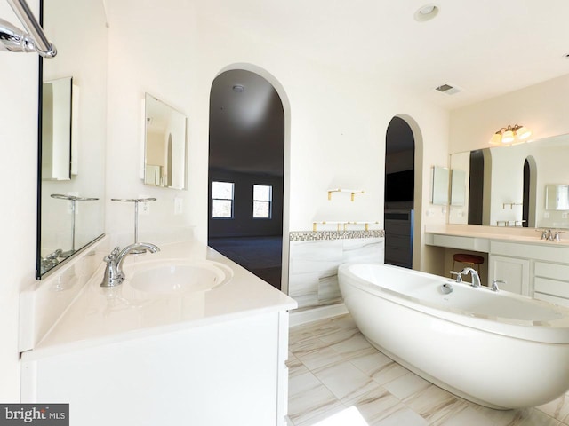 full bath featuring a wainscoted wall, visible vents, marble finish floor, a freestanding bath, and vanity