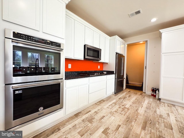 kitchen featuring visible vents, recessed lighting, appliances with stainless steel finishes, light wood-style floors, and white cabinets