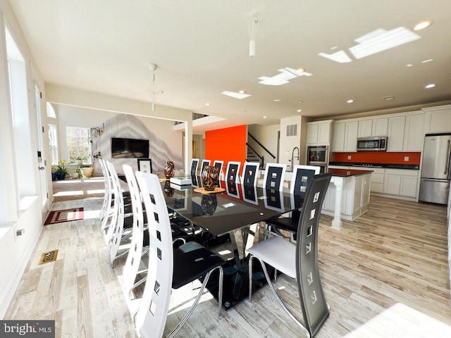 dining area with recessed lighting, stairway, light wood-style floors, and visible vents