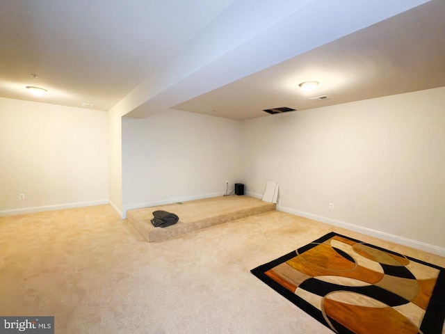 finished below grade area featuring carpet flooring, baseboards, and visible vents