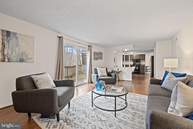 living area featuring a textured ceiling and wood finished floors