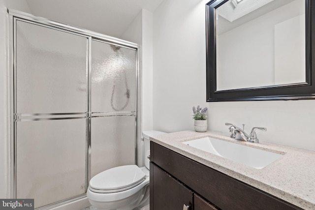 bathroom with a stall shower, vanity, and toilet