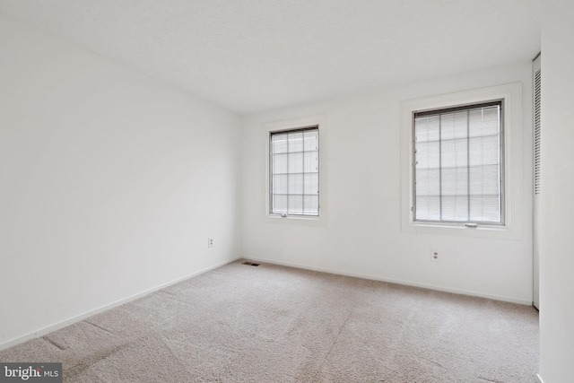 carpeted empty room with baseboards