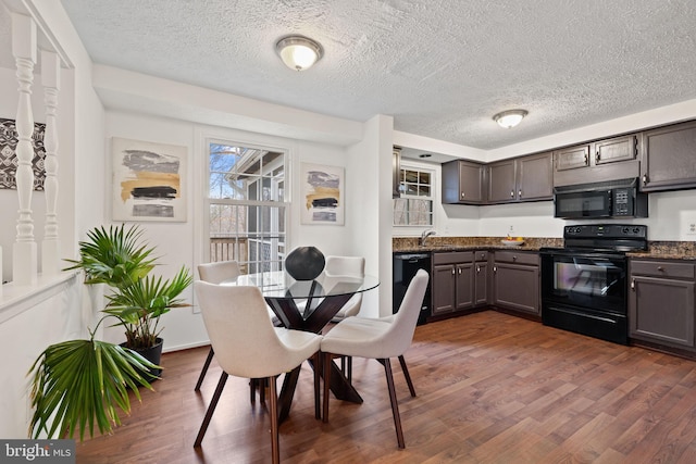 dining space featuring dark wood-type flooring and a textured ceiling