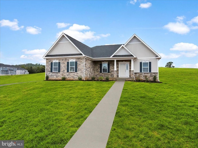 craftsman-style house featuring stone siding, board and batten siding, and a front yard