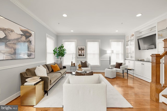 living area with recessed lighting, light wood-type flooring, a wealth of natural light, and crown molding