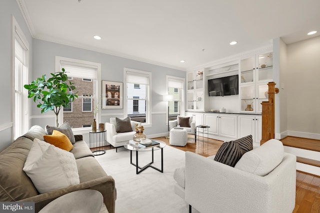 living room featuring a healthy amount of sunlight, light wood finished floors, ornamental molding, and recessed lighting