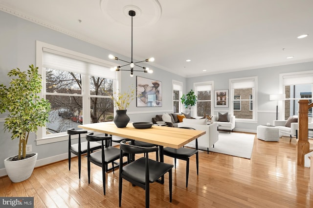 dining room with ornamental molding, a notable chandelier, and hardwood / wood-style floors