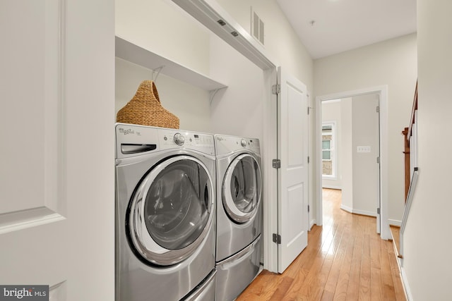 laundry room featuring laundry area, visible vents, washer and clothes dryer, and light wood-style floors