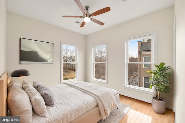 bedroom with ceiling fan, baseboards, and wood finished floors