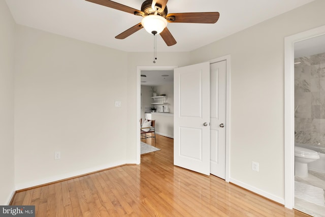 unfurnished bedroom with light wood-type flooring, connected bathroom, and baseboards