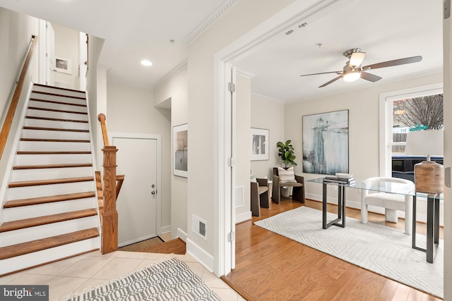 entrance foyer with baseboards, visible vents, ceiling fan, crown molding, and light tile patterned flooring