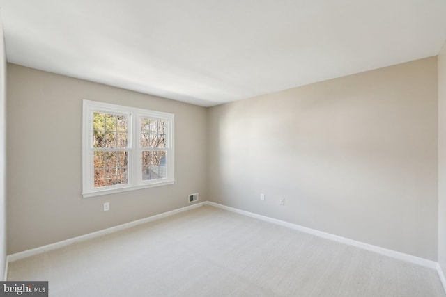 unfurnished room featuring light carpet, visible vents, and baseboards