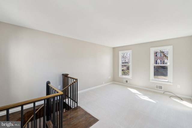 interior space featuring carpet floors, visible vents, and baseboards