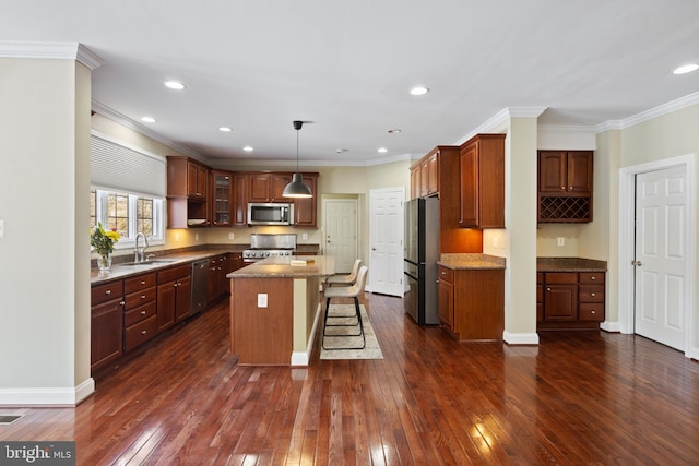 kitchen with dark wood-style floors, a kitchen island, glass insert cabinets, decorative light fixtures, and stainless steel appliances