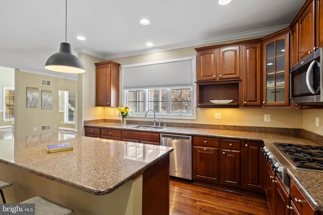 kitchen featuring visible vents, appliances with stainless steel finishes, a sink, and glass insert cabinets