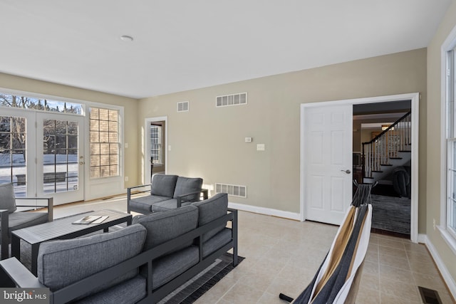 living area featuring stairs and visible vents
