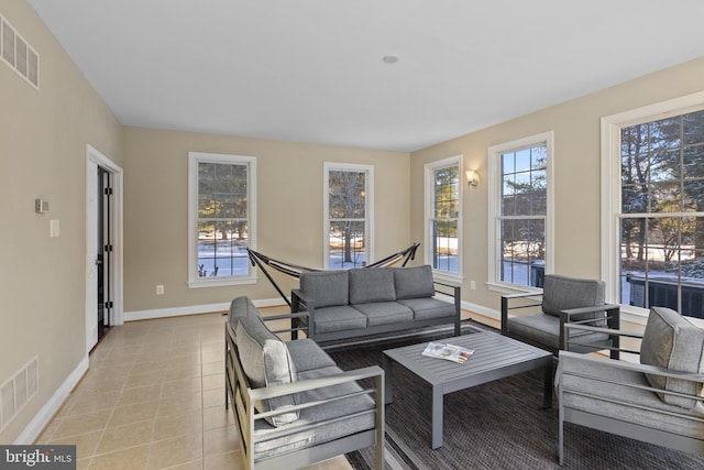 living room with light tile patterned floors, visible vents, and baseboards