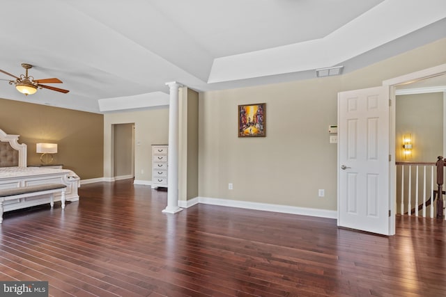 bedroom featuring dark wood-style floors, visible vents, decorative columns, and baseboards
