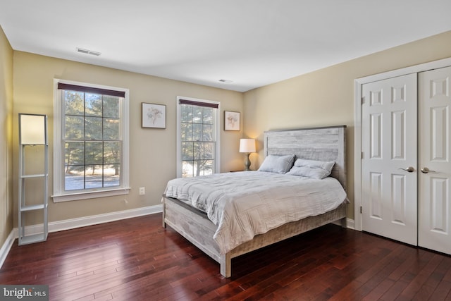 bedroom with dark wood-type flooring, visible vents, and baseboards
