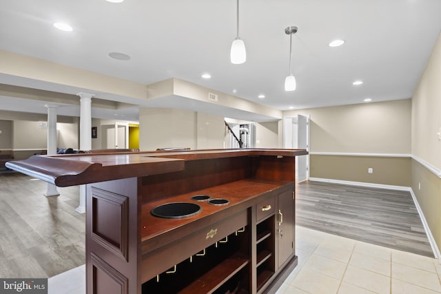 kitchen with light tile patterned floors, open floor plan, hanging light fixtures, open shelves, and dark countertops
