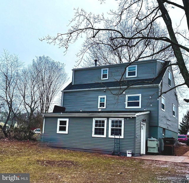 back of property featuring a lawn