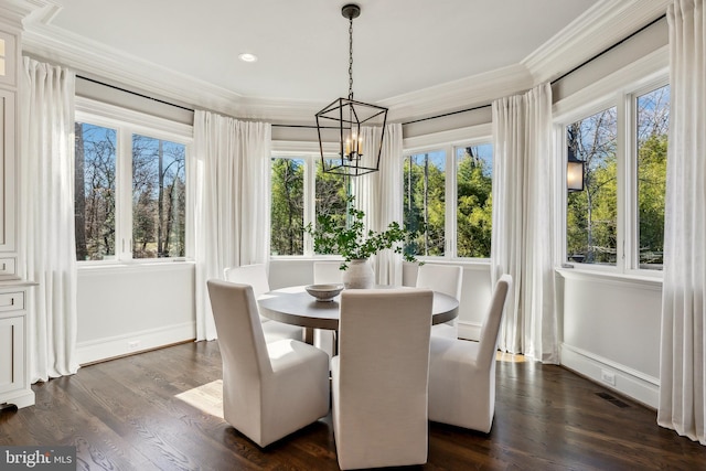 dining area featuring dark wood-style floors, a chandelier, crown molding, and baseboards