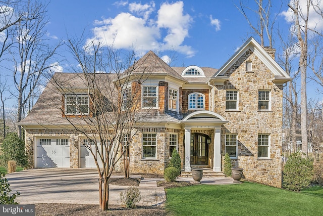 view of front of home with stone siding, driveway, and a front lawn