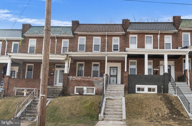 multi unit property featuring a tile roof, brick siding, and mansard roof