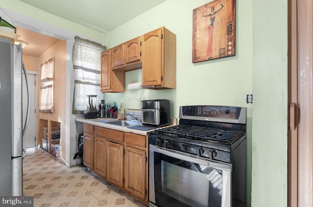 kitchen featuring stainless steel appliances, light countertops, and a sink