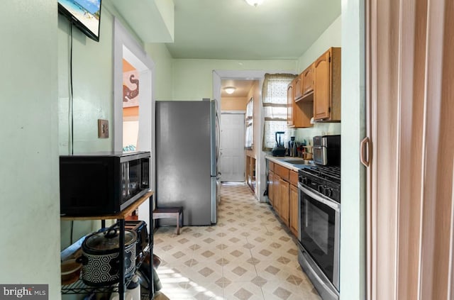 kitchen featuring brown cabinets, light floors, stainless steel appliances, and light countertops