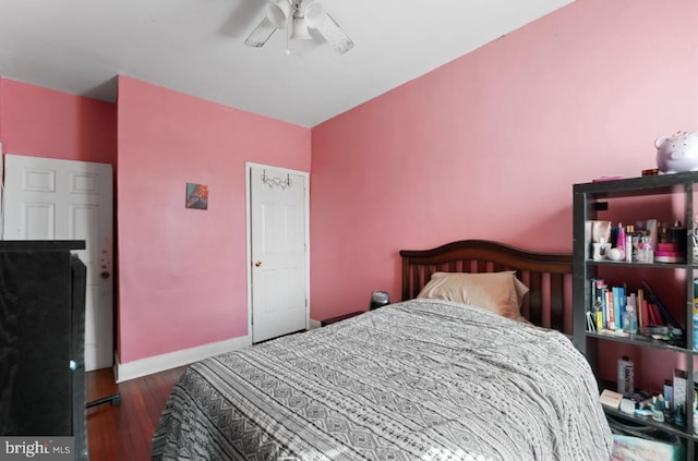 bedroom featuring ceiling fan, dark wood-type flooring, and baseboards