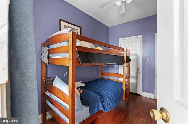 bedroom with a ceiling fan, dark wood-style flooring, and baseboards