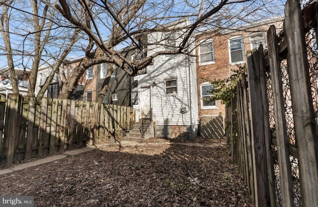 exterior space with entry steps, brick siding, and fence