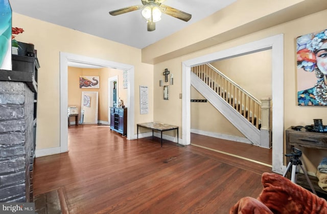 foyer featuring ceiling fan, dark wood-style flooring, stairway, and baseboards