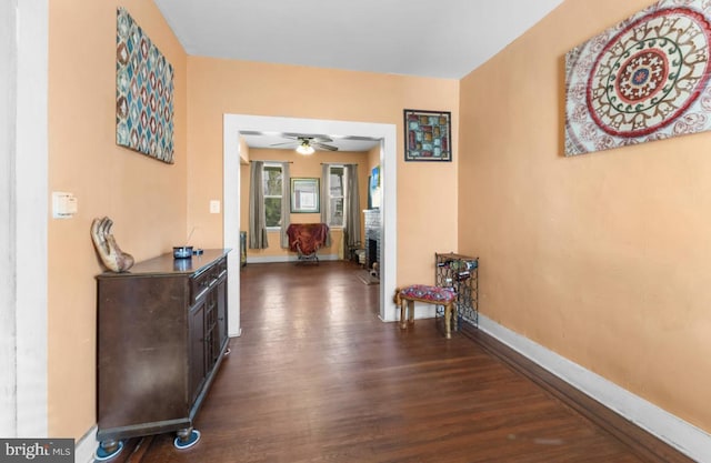 hall featuring dark wood-style floors and baseboards